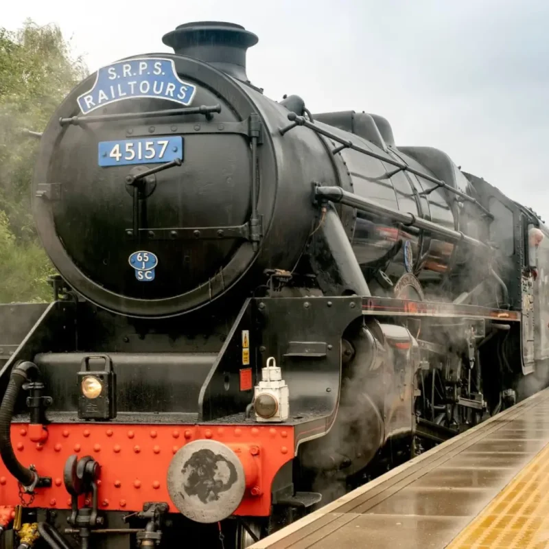 A couple admiring the Borders steam train from the platform at Tweedbank